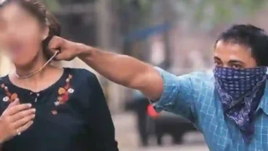 Man snatching chain from woman walking on road