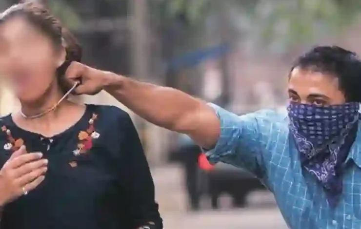 Man snatching chain from woman walking on road