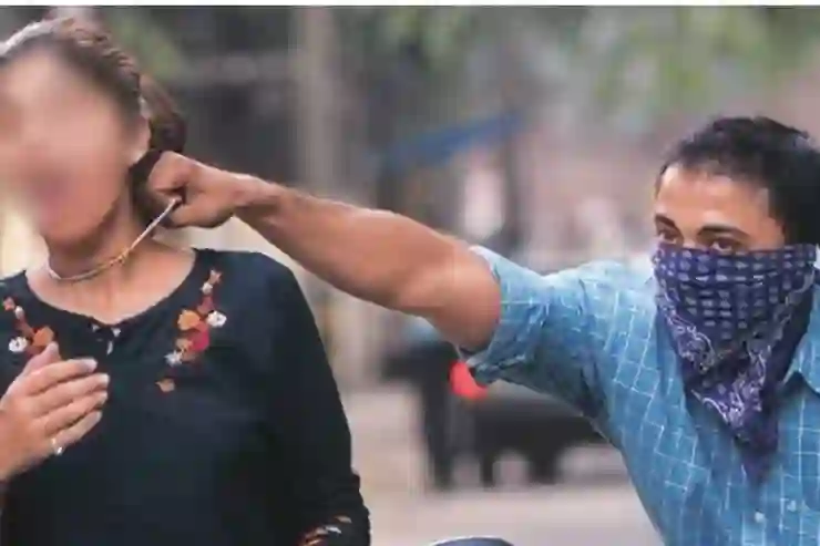 Man snatching chain from woman walking on road